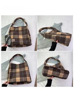 Detail view of brown plaid tote bag with BEAR patch and wide bottom structure
