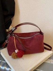 Minimalist burgundy suede tote bag with brown faux leather straps and pompom charm