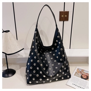 Close-up of a black hobo bag featuring polished silver metal rivets and a spacious interior