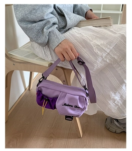 Detail view of the purple color-block crossbody bag with Mobern Bag embroidery