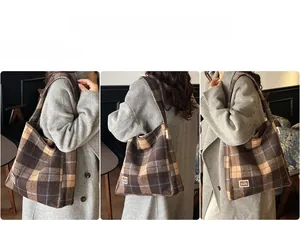 Detail view of the spacious brown plaid tote bag showing texture and label detail