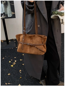 Gros plan d'un sac cabas en daim caramel avec œillets métalliques et bandoulière rétro
