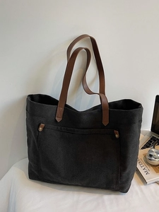 Large capacity black canvas tote bag with brown leather handles and a front rivet pocket