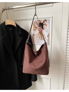 Detail of dark brown suede hobo bag featuring slim strap and sleek buckle closure