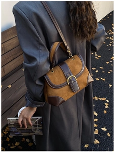 Scatto street style di una borsa a sella vintage in camoscio marrone e pelle liscia