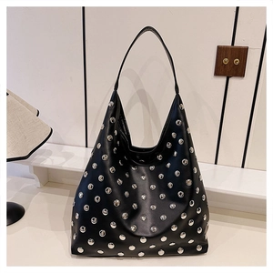 Detailed view of black punk style hobo bag with silver metal rivet studs and wide strap