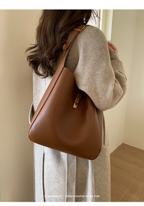 Brown retro leather tote bag with gold metal clasp shown on beige wool coat outfit