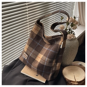 Detail of vintage checkered flannel tote bag with Bear logo patch and soft plush texture