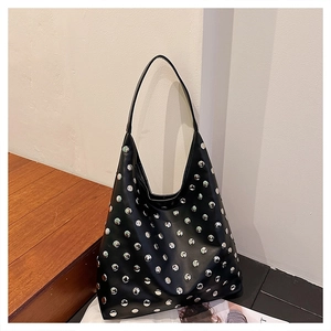 Detail of black hobo bag with vintage silver studs and glossy leather texture