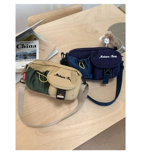 Detail of crossbody bags with buckle closure and drawstring pocket on wooden table