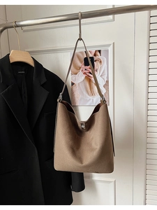 Macro detail of brown matte suede hobo bag featuring a silver metal twist lock closure