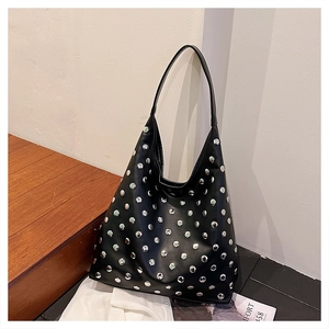 Close-up detail of silver stud decorations on the black leather hobo shoulder bag