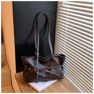 Détail d'un sac cabas vintage marron foncé en daim avec des accents d'œillets métalliques