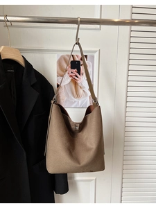 Detail view of brown faux suede bucket bag with a stylish silver metal buckle closure