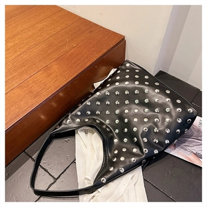 Detail of silver rivets on black PU leather hobo bag with vintage punk style aesthetic