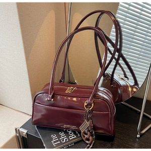 Détail du sac polochon vintage bordeaux avec finition brillante et zip doré