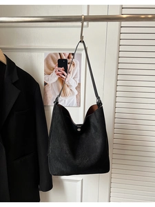 Detail view of the black frosted bucket bag showing magnetic closure and suede texture