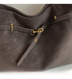 Macro detail of dark brown leather texture with vintage gold metal hardware buckle
