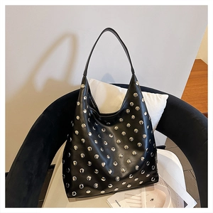 Detail of a black faux leather hobo bag with vintage silver rivets and sturdy shoulder strap