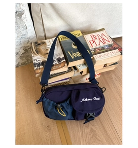 Detail of dark blue vintage crossbody bag with functional drawstring and flap pockets