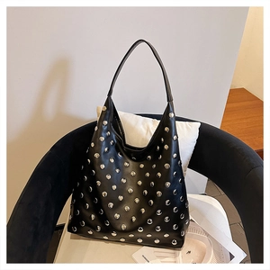 Detail of silver rivets on black leather hobo bag with seamless shoulder strap design