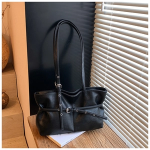 Détail du sac à épaule noir en similicuir avec boucle de ceinture et texture plissée