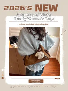 Détail d'un sac dumpling en daim marron avec un pendentif chien en peluche sur le côté