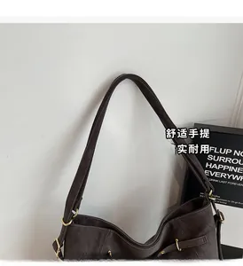 Close-up of wide shoulder strap and gold metal ring buckle on vintage brown leather bag
