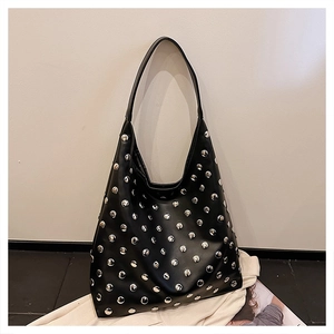 Detail view of large black glossy leather Hobo bag featuring silver rivet stud embellishments