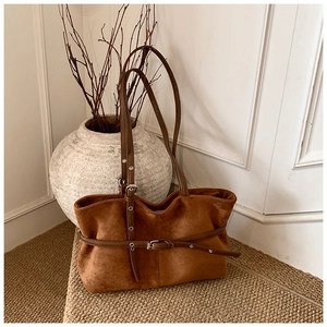 Détail du sac cabas vintage en daim marron avec sangles en cuir et boucles métalliques