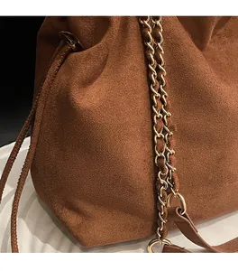 Gros plan du sac en daim marron avec chaîne dorée et logo de mode élégant