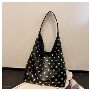 Detailed macro view of silver stud embellishments on high-quality black leather tote bag