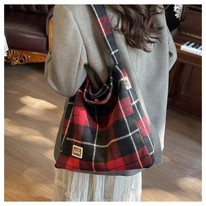 Detail of red and black plaid tote bag with leather BEAR patch and bear icon tag