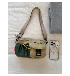 Detail of color-block nylon crossbody bag with side drawstring mesh pocket and adjustable strap