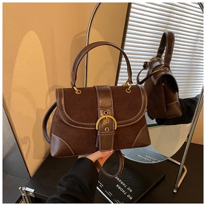 Detail of vintage coffee brown saddle bag with contrast stitching and gold buckle