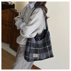 Detail shot of the large plaid tote bag with wide shoulder strap and BEAR label