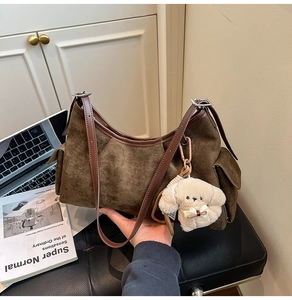 Détail du sac hobo marron mat avec poches latérales et porte-clés chien en peluche