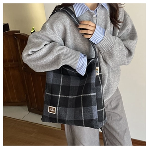 Detail view of large checkered plaid woolen tote bag with BEAR logo and black strap