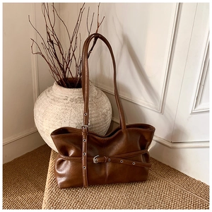 Détail du sac à bandoulière marron foncé rétro avec boucles de ceinture en cuir décoratives