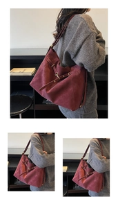 Close-up of vintage burgundy tote bag with gold hardware and stylish leather buckle detail