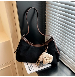 Détail du sac croissant avec bordure en cuir marron et breloque chien en peluche