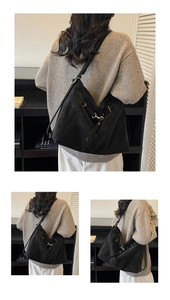 Detail shot of black suede tote bag showing its large capacity and golden buckle