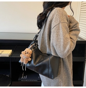 Detail of black large-capacity Hobo bag with adjustable strap and cute bear charm