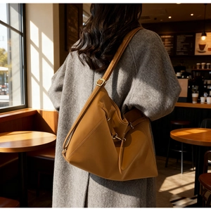 Detail of the adjustable shoulder strap and leather texture on a camel tote bag