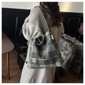 Close-up of textured plaid pattern on the large canvas tote bag with brown leather bear patch