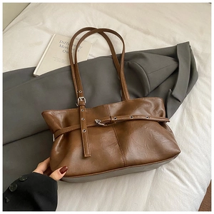 Close-up of caramel suede tote bag with adjustable silver buckle and matte texture