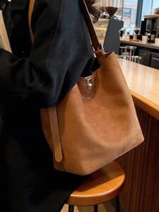 Brown suede bucket bag with metallic twist lock and large capacity for daily commute