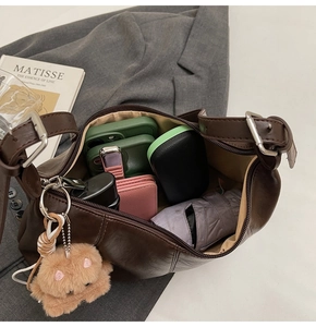 Deep brown leather hobo bag showing spacious interior with phones and accessories