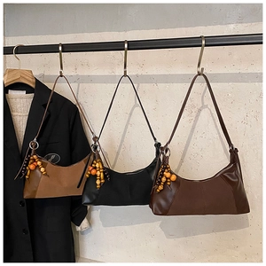 Détail de sacs demi-lune vintage en trois couleurs avec charmants pendentifs perlés