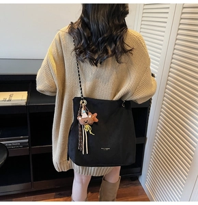 Détail du grand sac bandoulière noir avec chaîne en métal et breloque ours adorable